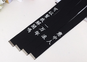 Détail de ceintures en toile noire avec calligraphie chinoise et embouts métalliques