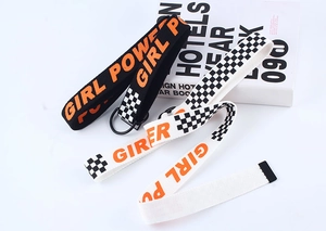 Détail de ceintures en toile avec texte Girl Power orange et boucles métalliques en double D