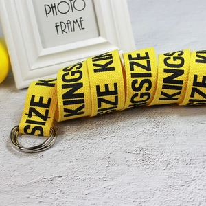 Detail of yellow canvas belt with double D-ring buckle and black KINGSIZE lettering