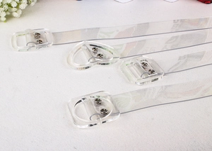 Close-up of transparent PVC belt with heart and square acrylic buckles and silver rivets