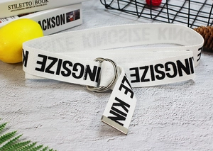 Detailed texture of white canvas belt with black letters and silver double D-ring buckle