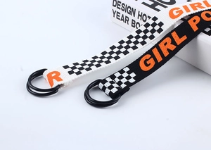 Détail de ceintures en toile avec boucles double anneau en D et texte orange Girl Power
