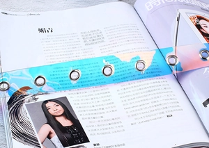 Détail de la ceinture en PVC iridescent laser avec œillets métalliques sur fond de magazine