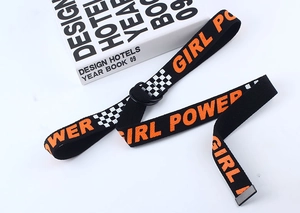 Détail d'une ceinture en toile noire avec texte Girl Power et boucle en métal double D