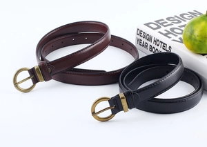 Dettaglio di cinture in pelle nera e marrone con fibbie rotonde in ottone vintage