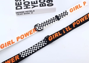 Détail des ceintures en toile avec doubles boucles en D et imprimé damier Girl Power