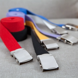 Detail view of woven canvas belts with silver buckles in red, black, and blue colors