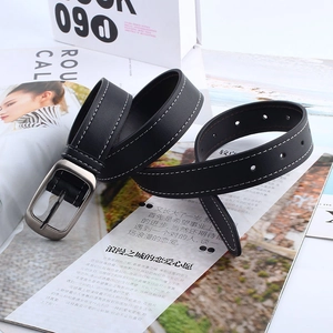 Détail d'une ceinture en cuir noir avec boucle argentée et surpiqûres blanches
