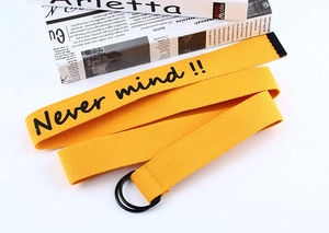 Detail view of ginger yellow canvas belt with black double D-ring and letter printing