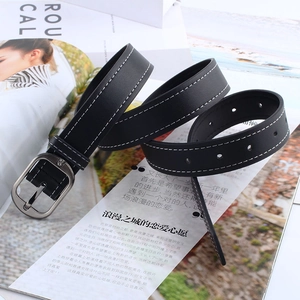 Détail d'une ceinture en cuir noir avec coutures blanches et boucle ovale argentée