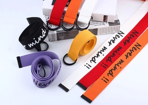 Detail of colorful canvas belts with Never Mind text and double D-ring metal buckles
