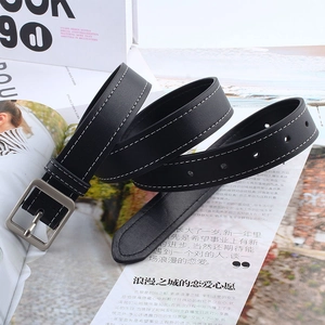 Gros plan sur une ceinture noire avec coutures blanches contrastées et boucle carrée