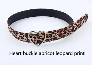 Détail d'une ceinture imprimé léopard abricot avec une boucle argentée en forme de cœur