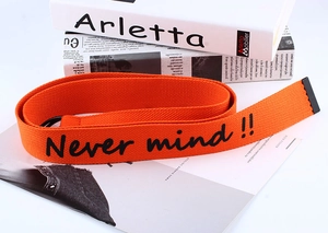 Detail of orange canvas belt with Never mind text and black double ring buckle