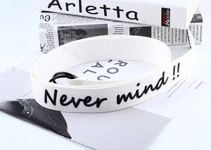 Detail of white canvas belt with Never mind text and black double ring buckle