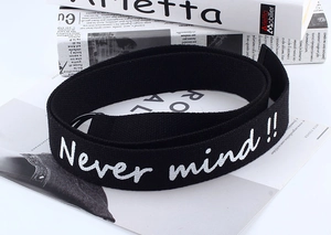 Detail of black canvas belt with white Never mind embroidery on lifestyle magazine base