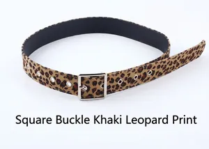 Détail d'une ceinture léopard jaune terre avec boucle carrée argentée et œillets