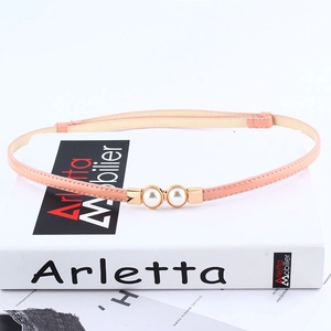 Detail of elegant pink thin leather belt with gold metal buckle and pearl accents