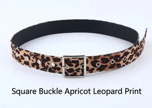 Détail de la ceinture léopard abricot avec boucle carrée argentée et œillets en métal