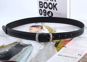 Détail d'une ceinture en cuir noir avec surpiqûres blanches et boucle en métal mat
