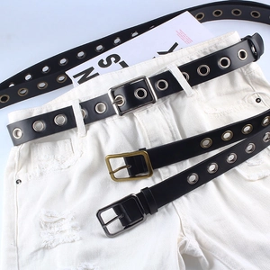 Ceinture noire à œillets en PU avec boucle carrée sur un jean blanc déchiré