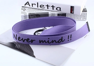 Detail of purple canvas belt with black Never Mind printing and double D-ring buckle