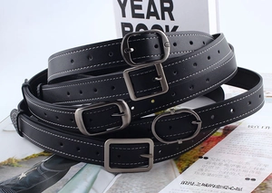 Détails de quatre ceintures en cuir noir avec boucles carrées et coutures blanches