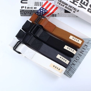 Detail of four canvas belts in white, gray, black, and brown with double D-ring buckles