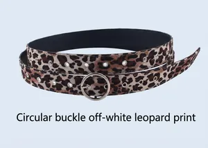 Détail de la boucle ronde argentée et motif léopard sur la ceinture blanc cassé