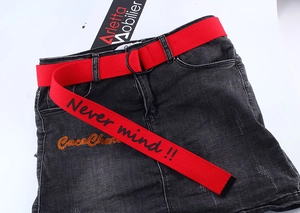 Close-up of red canvas belt with double D-ring buckle and 'Never mind!!' text print