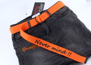 Detail view of orange canvas belt with black double D-rings and Never Mind slogan text
