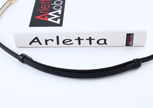 Detailed view of a slim black leather belt with fine stitching and a sliding leather loop