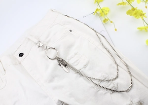 Close-up of double-layer silver metal pants chain with feather pendant on white denim