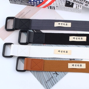Detail of four colorful canvas belts with double D-ring buckles and Korean fashion labels