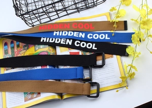 Trois ceintures en toile avec boucle double anneau et imprimé Hidden Cool sur fond lifestyle