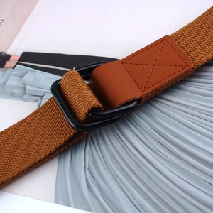 Close-up of caramel brown woven canvas belt with black double D-ring metal buckle