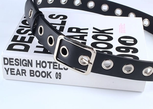 Détail de la ceinture en cuir PU noir avec œillets métalliques argentés et boucle carrée simple