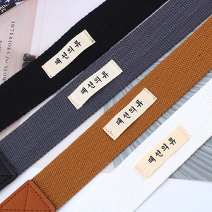 Detail showing the heavy-duty canvas belt texture and stylish stitched labels in four colors