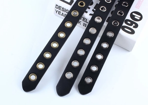 Détail de ceintures en cuir noir avec rivets à œillets en bronze, argent et bronze noir
