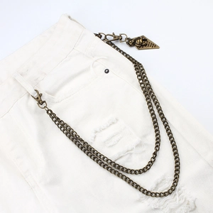 Close-up of double-layer bronze hip hop chain with bear pendant on denim pants