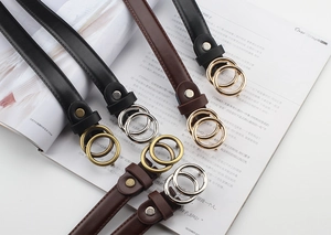 Close-up of vintage thin leather belts with double ring buckles in black and brown colors