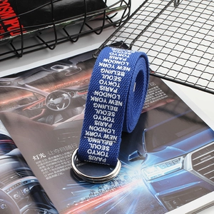 Detail of navy canvas belt featuring white city name prints and double D-ring metal buckle