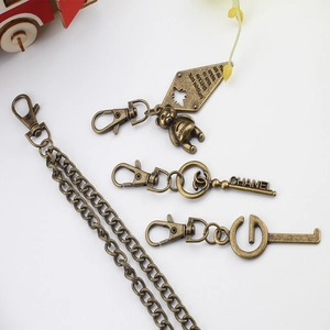 Detail of vintage bronze alloy keychain charms with metallic chain and brand engravings