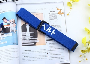 Détail d'une ceinture en toile bleu roi avec boucle double anneau en D et imprimé blanc