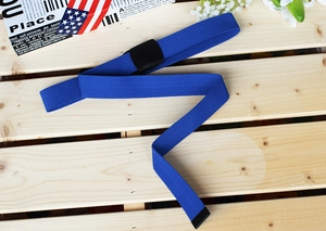 Flat lay of navy blue nylon canvas belt with a black buckle on a wooden surface