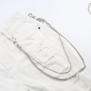 Chaîne de pantalon double en métal argenté avec mailles gourmette sur jean blanc