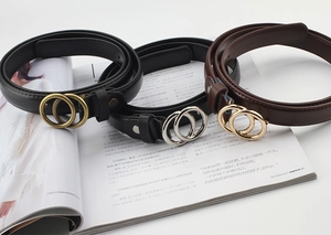 Close-up of vintage thin leather belts with elegant double circle metal buckles