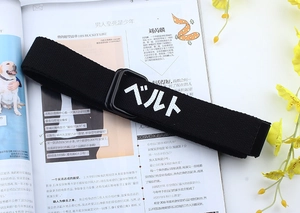 Détail de la ceinture en toile noire avec double boucle D noir mat et texte blanc imprimé