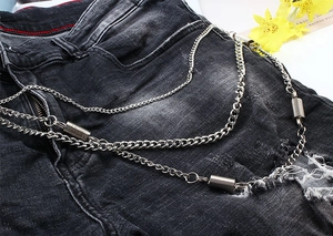 Detail of silver double-layered hip-hop metal trouser chain on distressed black jeans