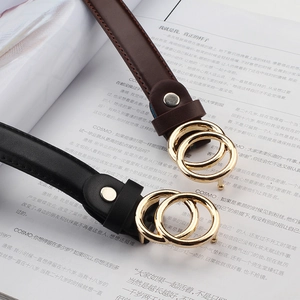 Retro double-ring buckle skinny leather belt in black and brown over a fashion magazine